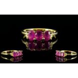 Ruby and White Topaz Ring, a trio of oval cut rubies, accented with small, round white topaz,