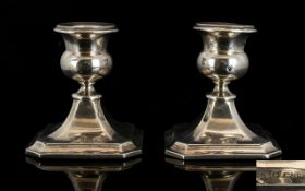 A Pair Of Squat Sterling Silver Candlesticks Of plain form raised on square base,