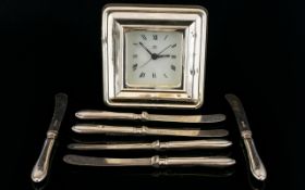 A Modern Silver Fronted Battery Operated Desk Clock Together with six silver handle butter knives