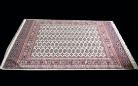 A Large Woven Silk Bokhara Carpet Ornate silk carpet with traditional lozenge and geometric repeat