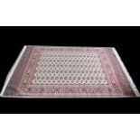 A Large Woven Silk Bokhara Carpet Ornate silk carpet with traditional lozenge and geometric repeat