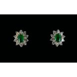 A Pair Of Diamond And Emerald Cluster Stud Earrings The central green emeralds surrounded by 10