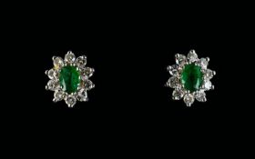 A Pair Of Diamond And Emerald Cluster Stud Earrings The central green emeralds surrounded by 10