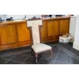 A Late 19th Early 20th Century Nursing Chair High back with low seat and carved detail to legs and