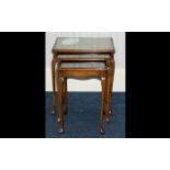 A Nest of Tables of typical form with glass inlay to tops and carved Queen Anne legs,