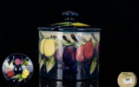 William Moorcroft Signed Round Lidded Preserve Pot with ' Plums ' Design on Blue Ground. c.1925.