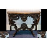 A Continental Adapted Console Table With figural supports and carved floral and dolphin decoration.