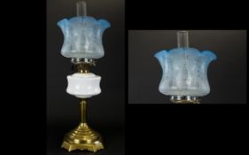 A Late Victorian Oil Lamp Brass support with milk glass reservoir complete with blue glass shade.