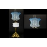 A Late Victorian Oil Lamp Brass support with milk glass reservoir complete with blue glass shade.