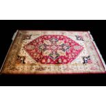 A Large Woven Silk Heriz Carpet Finley woven rug on red ground with intricate scrolling floral and