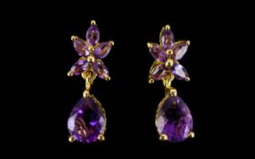 Amethyst Pair of Drop Earrings, pear cut solitaire amethysts suspended below flower or star shapes,