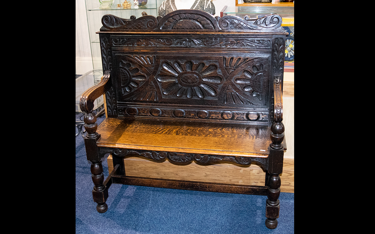 A Jacobean Style Oak Hall Bench - With carved backrest, turned supports, plank seat.
