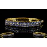 Tanzanite Double Row Hinged Bangle, two rows of oval cut tanzanites, totalling 9cts,