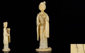 Japanese Meiji Period Well Carved Signed Ivory Figure of a standing Geisha girl holding a large