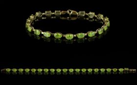 A 9ct Yellow Gold And Peridot Set Tennis Bracelet Fully hallmarked,