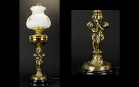 A Victorian Style Converted Oil Lamp Brass figural support with reservoir complete with clear glass