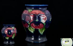 Moorcroft Small Tubelined Vase 'Clematis' design on blue ground.