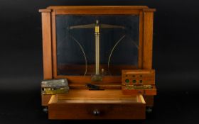 A Set Of Scientific Pan Scales In mahogany case with glazed sides,