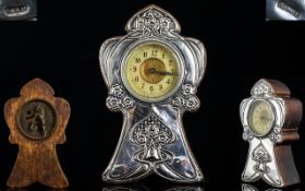 Art Nouveau Desk Clock Of stylised sagittiform oak case with embossed silver panel of whiplash