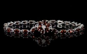 Red Garnet Line and Flower Bracelet, a floral shape comprising six pear cut red garnets, centred