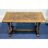 An Oak Coffee Table By Bath Easton And Chingford Of typical rustic form with turned supports.