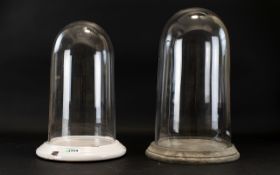 Two Glass Display Domes Each with circular ceramic base and domed glazed cloche. Tallest 15.