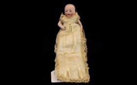 Antique German Bisque Miniature Infant Doll Circa 1910, comprising moving limbs with painted face,