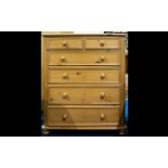 A Pine Chest Of Drawers raised on bun feet comprising x2 short over x4 long drawers..