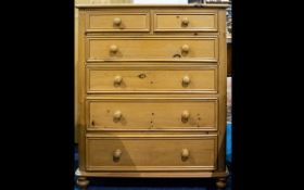 A Pine Chest Of Drawers raised on bun feet comprising x2 short over x4 long drawers..