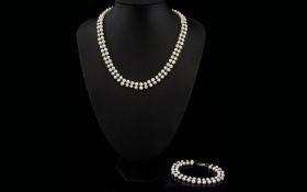 A Double Strand Cultured Pearl Necklace Together with matching bracelet, each with silver clasps,