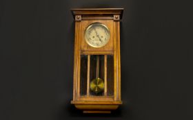 A 1930's Wall Mounted Clock In rectangular glazed case, Of typical form with brass dial. 28 inches