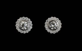 A Pair Of 18ct White Gold And Diamond Set Halo Earrings The central diamonds of approx 1.