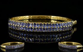 Tanzanite Double Row Hinged Bangle, two rows of oval cut tanzanites, totalling 9cts,