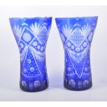 Pair of overlaid blue glass vases and a similar vase.
