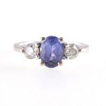 A tanzanite and diamond three stone ring, an oval mixed cut tanzanite 7.2mm x 5.