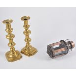 A pair of brass candlesticks, two small copper/metal lanterns,