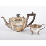 A silver teapot and a cream jug,