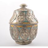 A middle eastern ceramic vessel with cover pale ground with a design in turquoise and yellow all