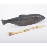 A Inuit hardstone carving of a fish, 30cm, a Lapland decorated bone paper knife 24cm.