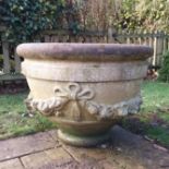 Pair of Haddonstone circular planters, decorated with flowers and ribbon ties, 53cms.
