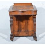 Victorian oak Davenport, the pen box above a slope writing surface, carved paw supports,