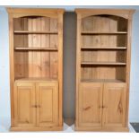 Pair of pine bookcases, shelves above cupboard, W87cm x D39cm x H187cm.
