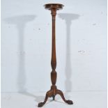Mahogany torchere with a circular top, octagonal baluster column, tripod legs, ball and claw feet,
