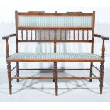 Victorian walnut double chair back settee, the back with turned and ringed spindles, shaped arms,