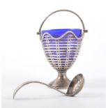 A silver pedestal sugar basket, pierced design with bead edge rim and handle, blue glass liner,