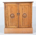 Oak side cabinet, rectangular top with a moulded edge, two carved panelled doors enclosing a shelf,