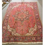 Persian carpet, central floral medallion on a crimson ground,