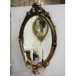 Large oval gilt framed girandole, late 19th century, moulded gesso cresting above oval plate,