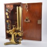 A brass binocular microscope in a fitted mahogany case,