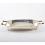 A silver bread basket, boat shape on four scroll feet with an ivory handle to each side,